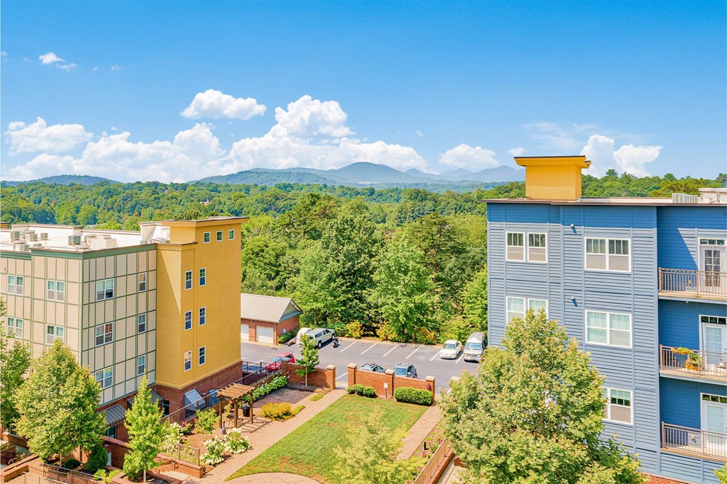 A view of a building with a yellow top and a blue building with a balcony at The Lofts at Reynolds Village Apartments, Asheville