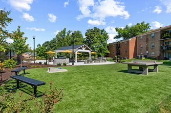 a park with picnic tables and a gazebo in front of a building at Courthouse Square Apartments, Maryland, 21286