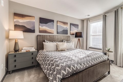 a bedroom with a bed and paintings on the wall at Dartmoor Place at Oxford Square Apartments, Hanover, Maryland