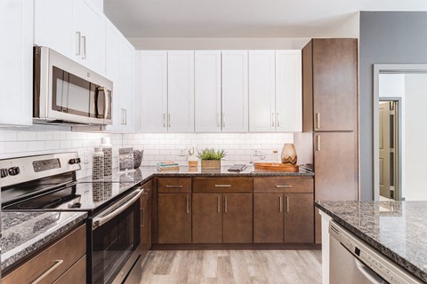 A kitchen with brown cabinets and a black granite countertop.