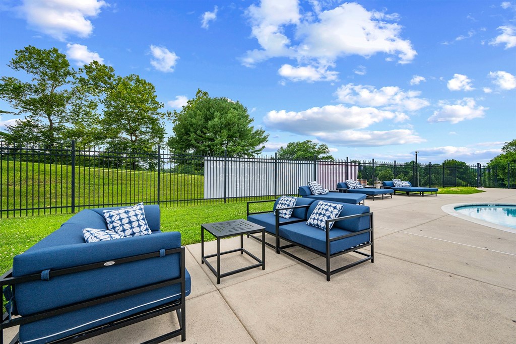 A blue sofa and a black coffee table are on a patio.