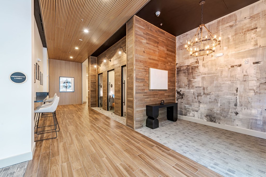 A hallway with a wooden floor and a stone wall at The Edison Lofts Apartments, Raleigh, NC