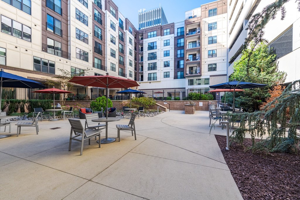 A courtyard with tables and chairs surrounded by buildings at The Edison Lofts Apartments, Raleigh, 27601