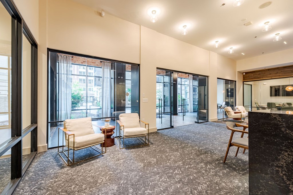 A leasing office with a black marble counter top and white chairs at The Edison Lofts Apartments, Raleigh, 27601