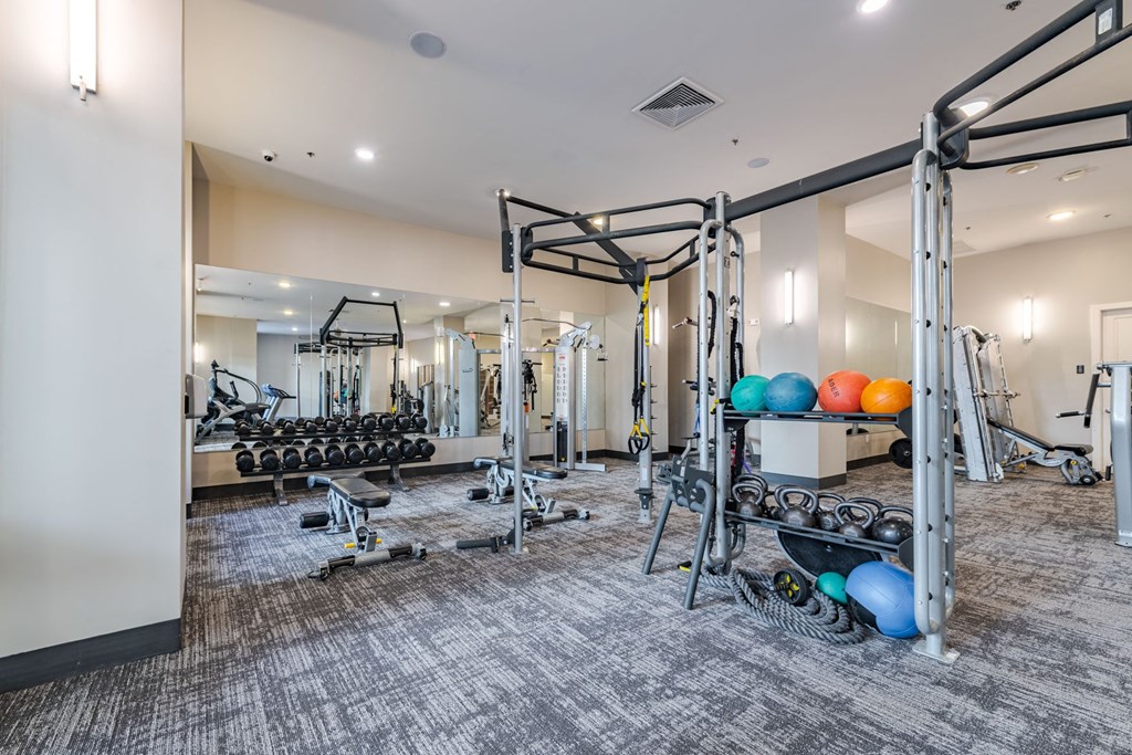 A gym with a variety of equipment including weights and weight machines at The Edison Lofts Apartments, Raleigh, NC, 27601