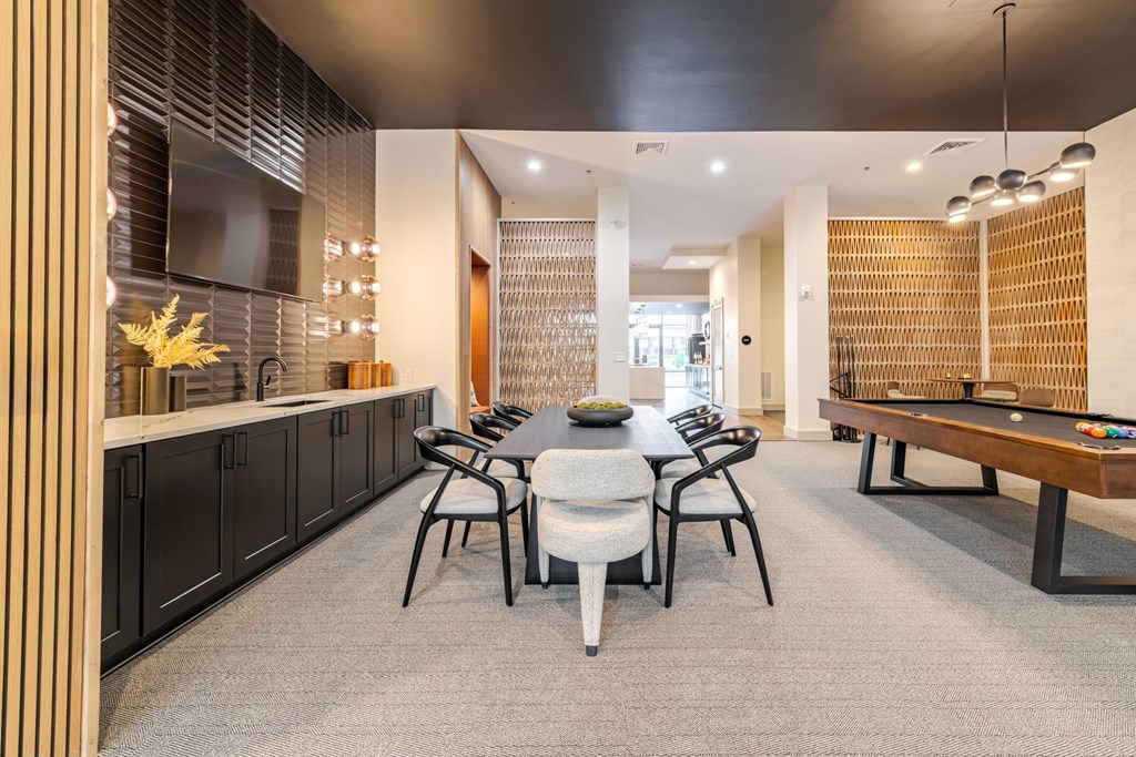A modern clubhouse room with a table set for four at The Edison Lofts Apartments, Raleigh, NC