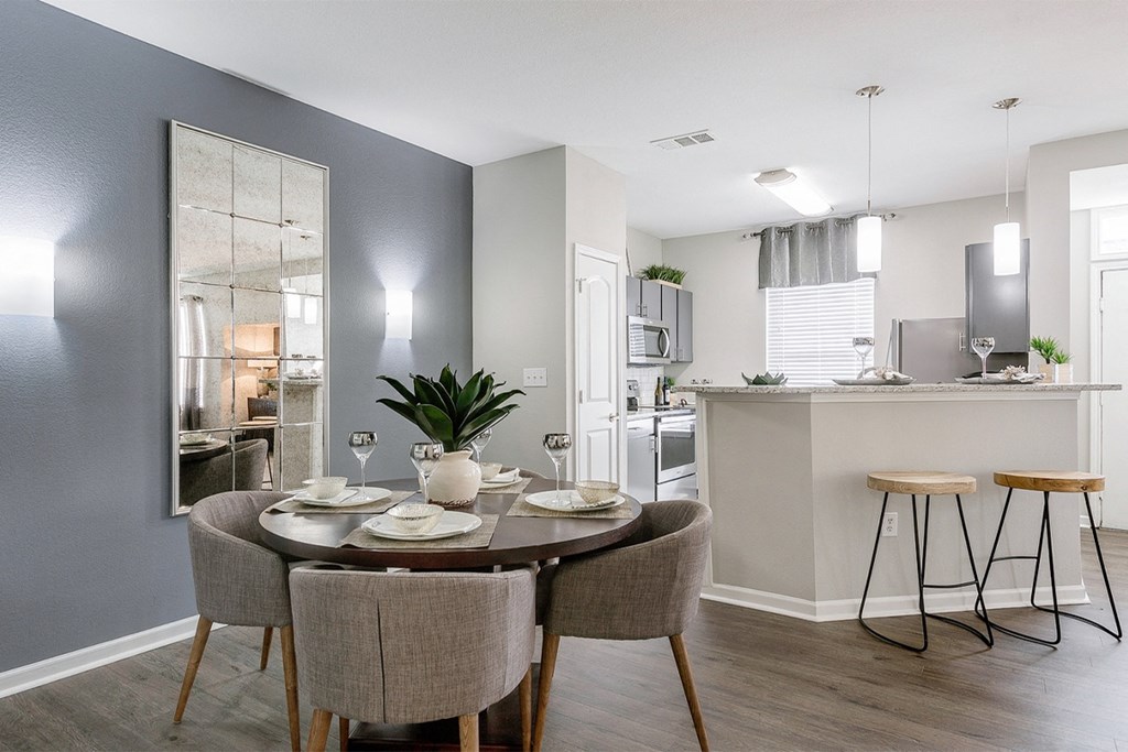 a dining area with a table and chairs and a kitchen in the background at Fortress Grove, Tennessee