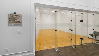 racquetball court with glass walls and a wooden floor, Henley Tampa Palms, Tampa, FL