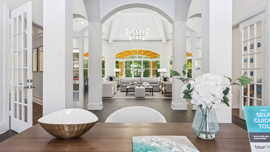 resident lounge with a table and a vase of flowers at Henley Tampa Palms Apartments, Tampa, FL