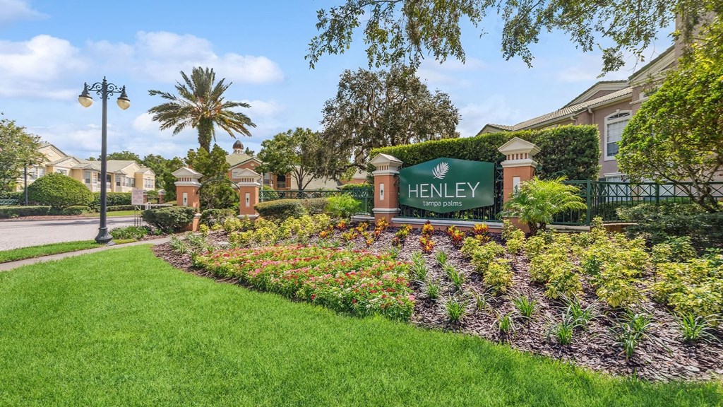 the sign is in front of a garden at Henley Tampa Palms Apartments, Tampa, Florida