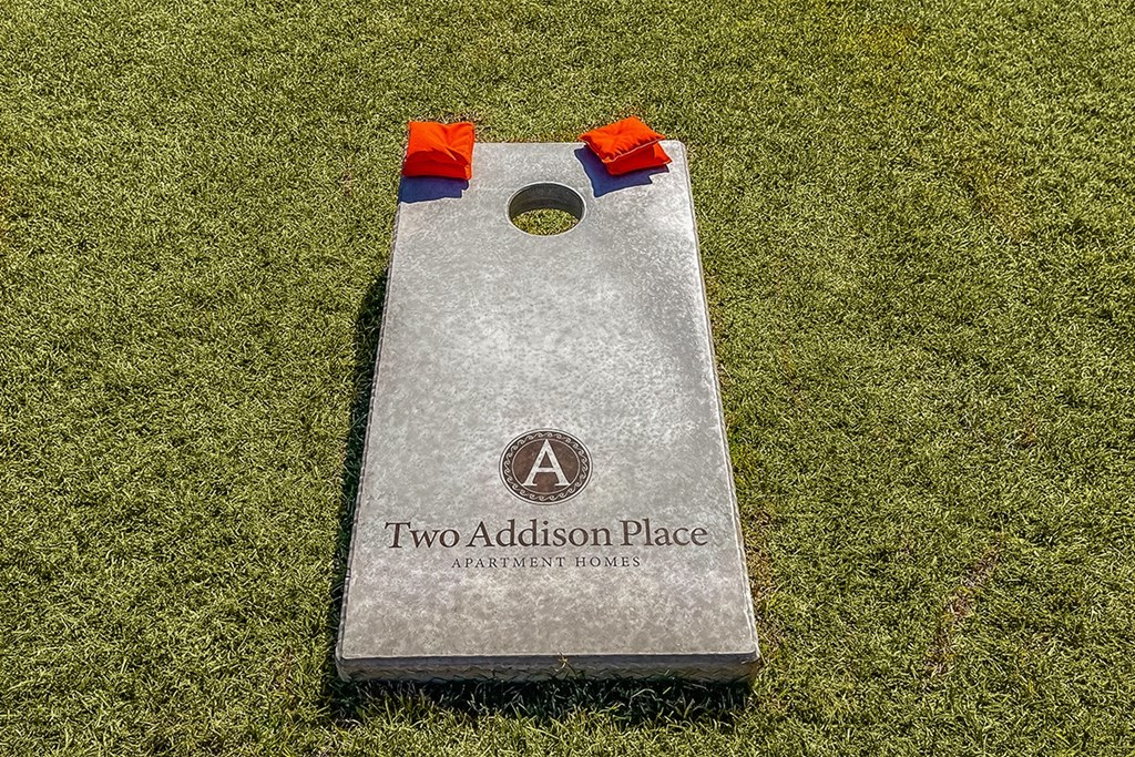 Cornhole board and bags in outdoor game area  at Two Addison Place Apartments , Pooler, Georgia