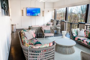 a rooftop lounge with wicker furniture and a television at Park and Kingston, Charlotte, 28203