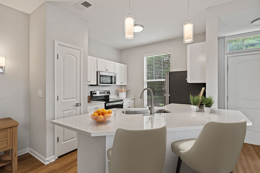 a kitchen with white cabinets and a white island with a bowl of fruit on it at Fortress Grove, Murfreesboro, TN