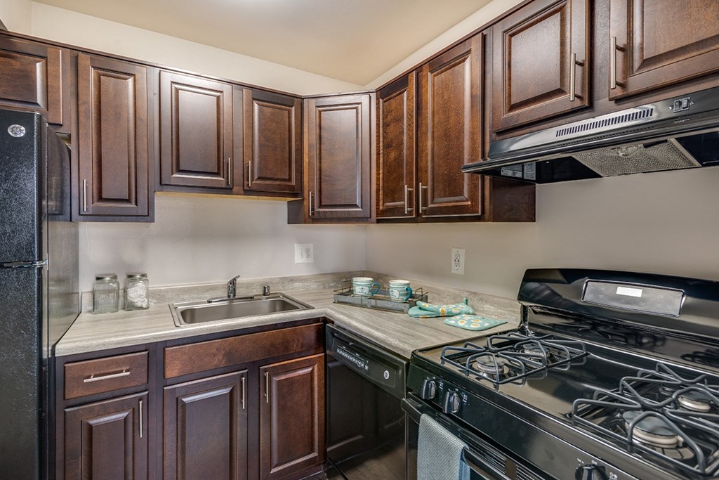 a kitchen with dark wood cabinets at Doncaster Village Apartments, Parkville, 21234