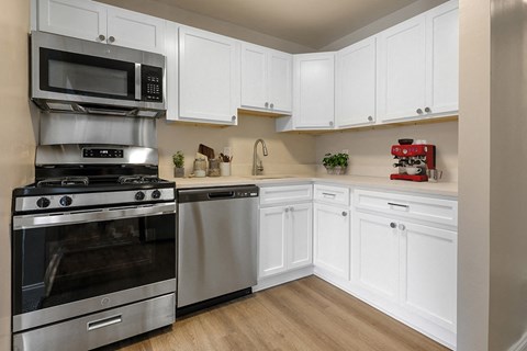 a kitchen with stainless steel appliances and white cabinets