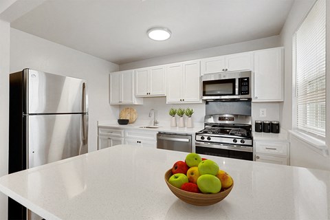 a kitchen with a bowl of fruit on the counter