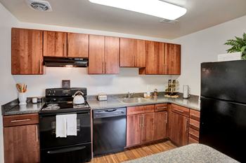 a kitchen with wooden cabinets and black appliances, Kenilworth at Charles Apartments, Towson, MD