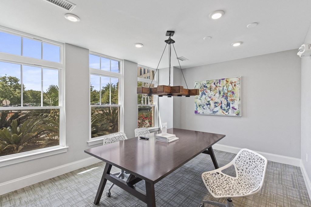 a dining room with a table and chairs and windows at Central Island Square, Daniel Island, 29492