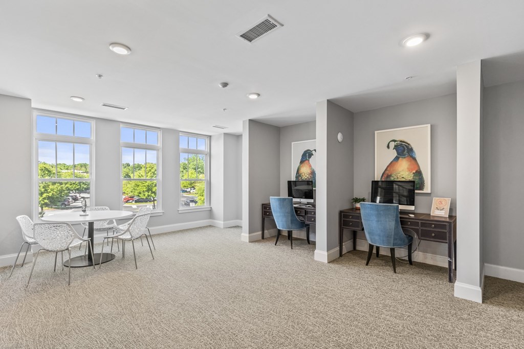 a living room with a table and chairs and a desk and windows at Central Island Square, Daniel Island, SC
