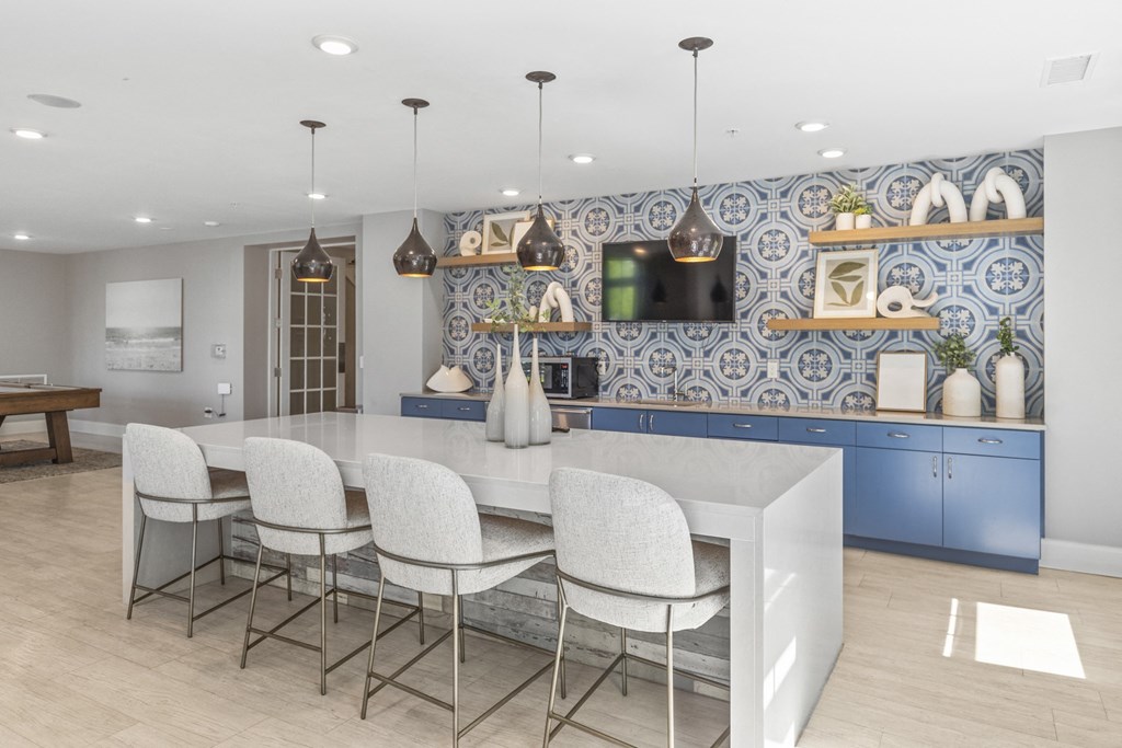 a kitchen with blue cabinets and a white island with chairs at Central Island Square, Daniel Island, 29492