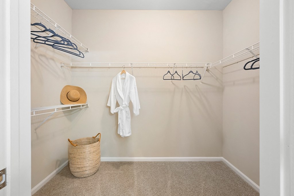a walk in closet with a white robe and a basket on the floor at Sweetgrass Landing, Mount Pleasant, 29466
