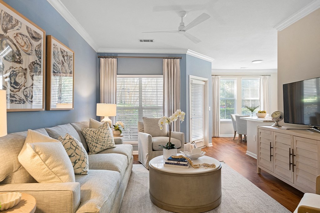 a living room with blue walls and a couch and a table at Sweetgrass Landing, Mount Pleasant