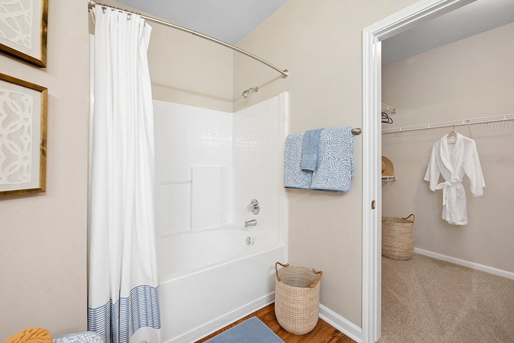 a bathroom with a white tub and a shower and blue towels at Sweetgrass Landing, Mount Pleasant, South Carolina