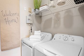 a washer and dryer in a laundry room with a sign saying welcome home at Sweetgrass Landing, South Carolina, 29466