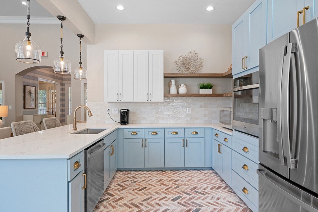 a kitchen with blue cabinets and a sink and a refrigerator at Sweetgrass Landing, Mount Pleasant, South Carolina