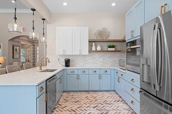 a kitchen with blue cabinets and a sink and a refrigerator