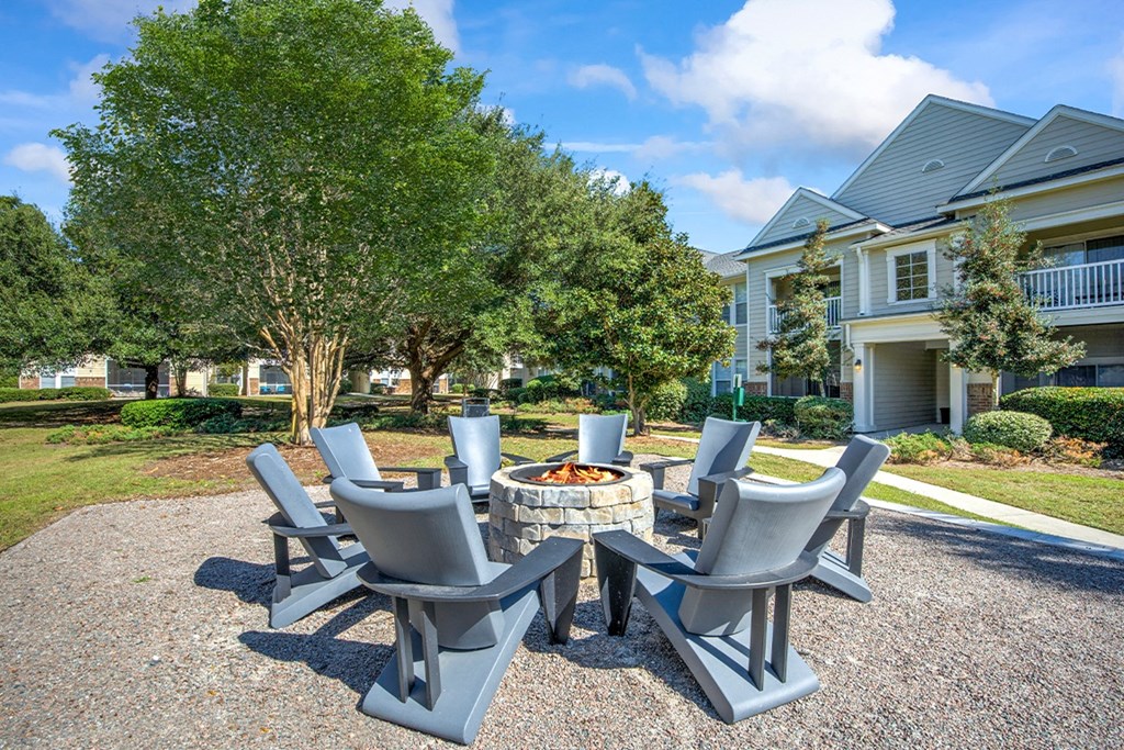 a patio with a fire pit and chairs in front of a house at Sweetgrass Landing, Mount Pleasant