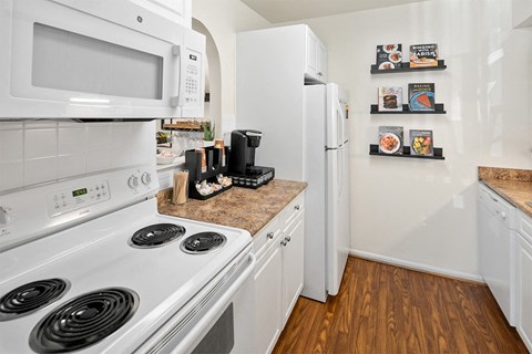 a kitchen with white appliances and a white refrigerator