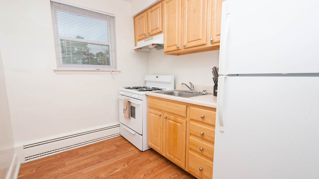kitchen with cabinets and white range at Mount Ridge Apartments, Baltimore MD