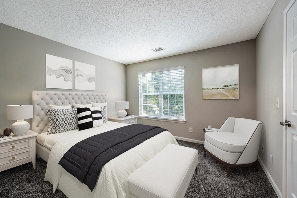 a bedroom with a bed and a chair at The Village Apartments, Raleigh, NC