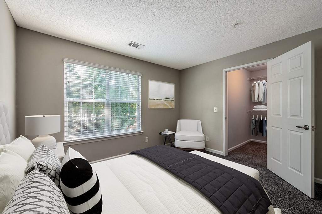 a bedroom with a large bed and a closet  at The Village Apartments, Raleigh, 27615