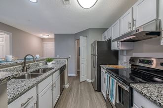 an open kitchen with granite counter tops and stainless steel appliances