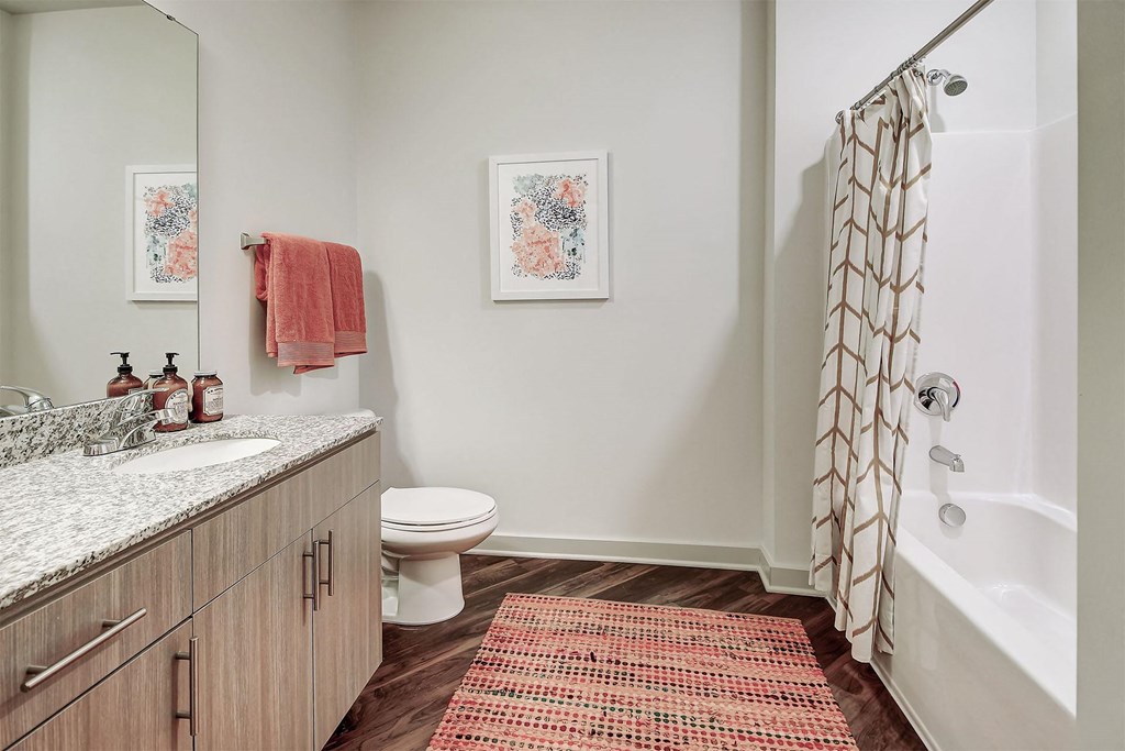 A bathroom with a toilet, sink, and shower at The Linden Apartments, North Carolina 28036