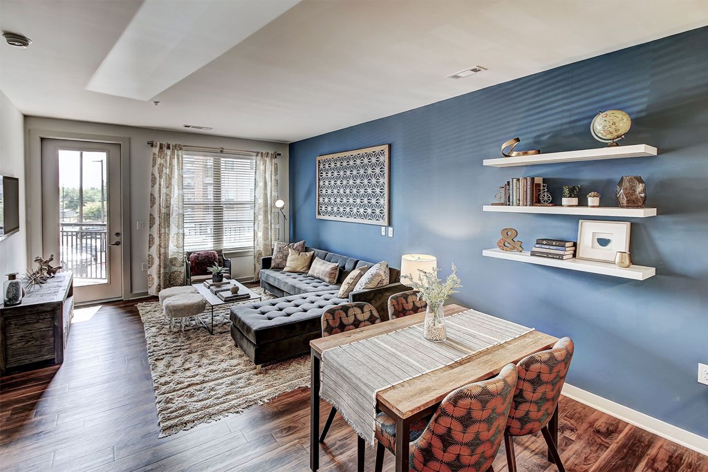 A living room with a blue wall and a wooden table at The Linden Apartments, Davidson, NC