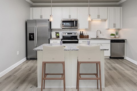 a kitchen with an island with two chairs