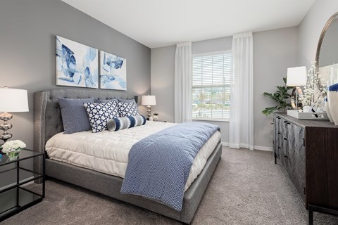 A bedroom with a large bed and a mirror on the wall.
