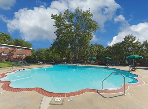 a large swimming pool with umbrellas in front of a building