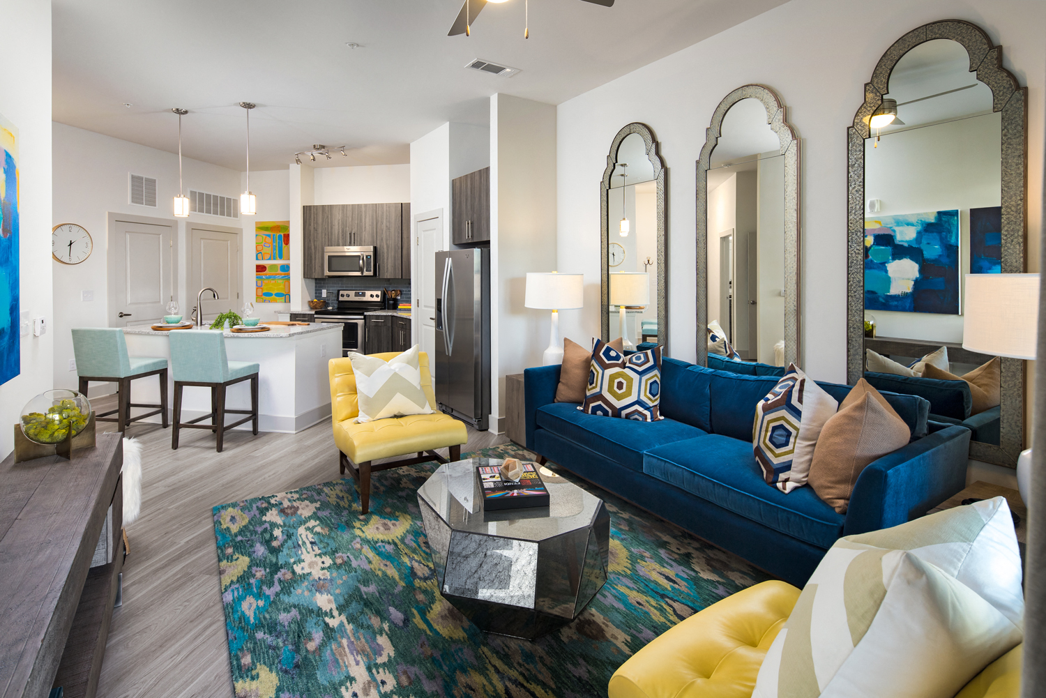 a living room with a blue couch and yellow chairs
