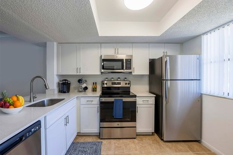 A kitchen with white cabinets and stainless steel appliances.