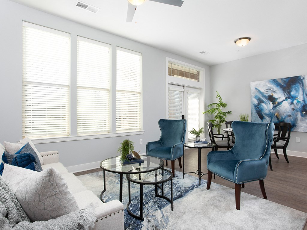 Living room with couch and blue chairs at St Mary's Square North Apartments, Raleigh