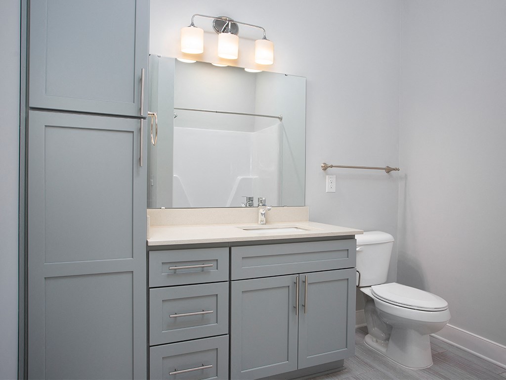 Guest bathroom with vanity and storage at St Mary's Square North Apartments, Raleigh, 27605