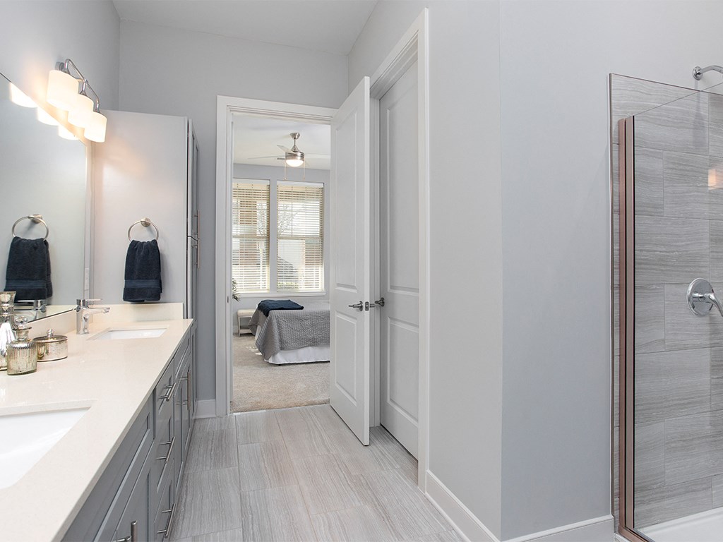 Primary bath with glass shower and vanity at St Mary's Square North Apartments, North Carolina