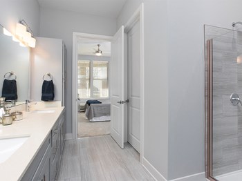 Primary bath with glass shower and vanity at St Mary's Square North Apartments, North Carolina - Photo Gallery 19