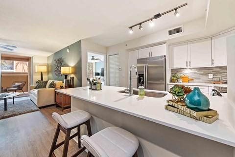 A kitchen with a white countertop and a refrigerator.