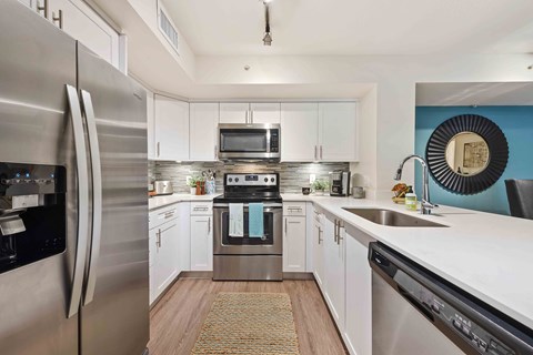 A modern kitchen with stainless steel appliances and white cabinets.