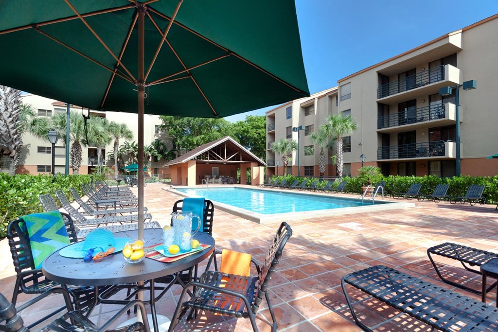 a patio with a table and chairs next to a swimming pool